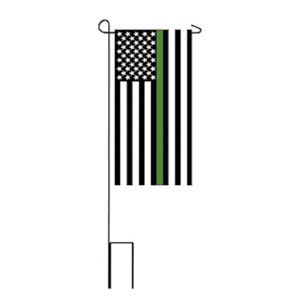 A black and white flag with the American stars and stripes with one vertical thin vertical line representing the military mounted on a pole.